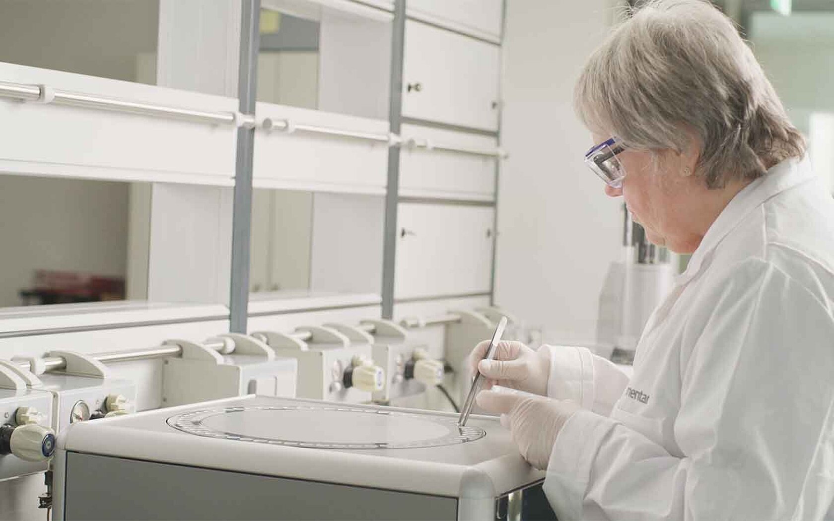 Female lab employee is placing samples on an elemental analyzer