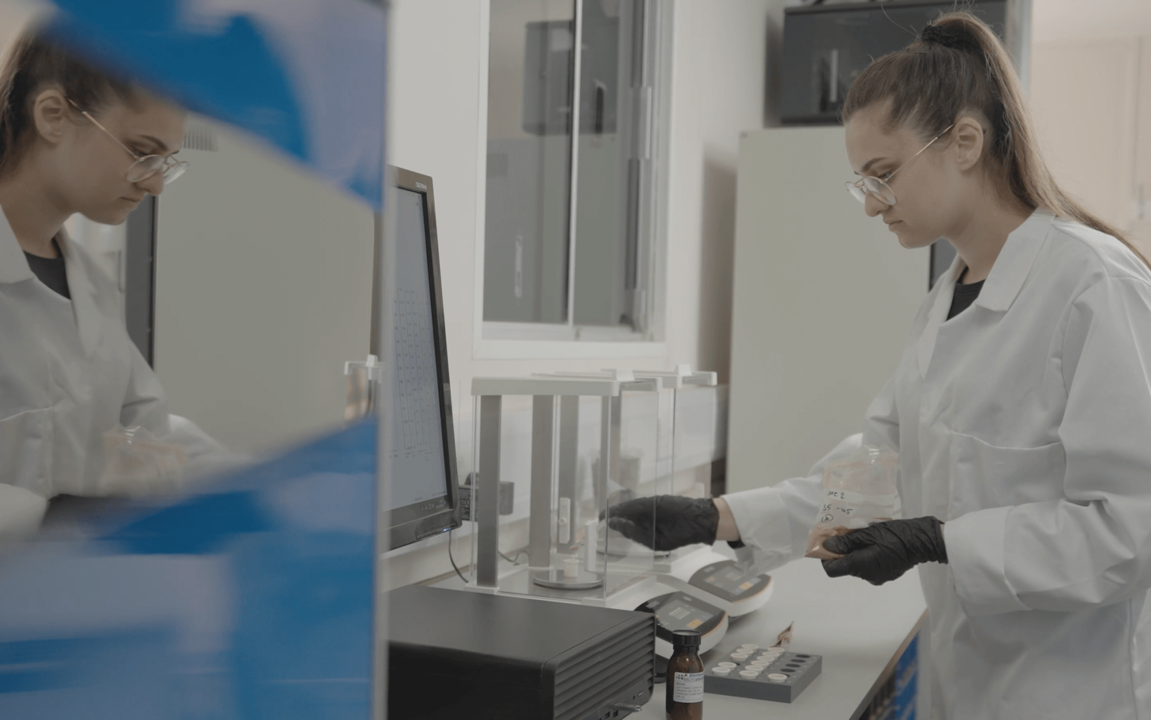 Image shows the soli TOC cube and a lab technician from Verdant Carbon. She is weighing samples.
