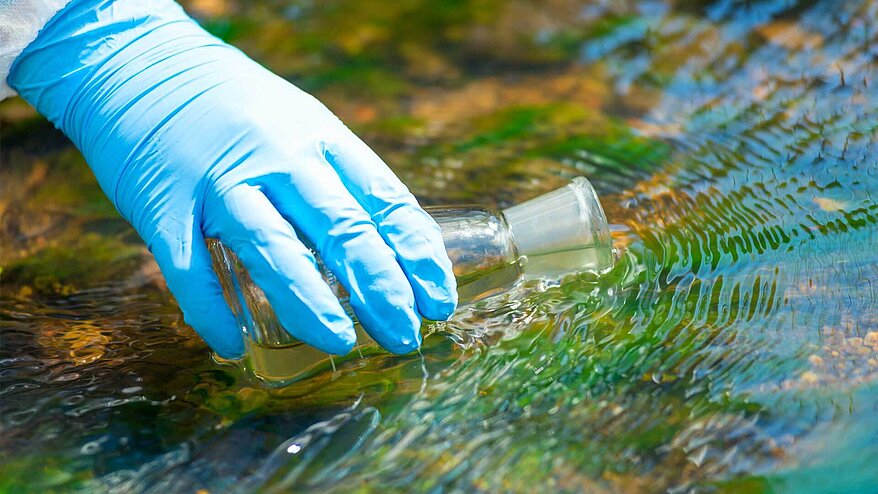 Drawing water into a research flask from a stream