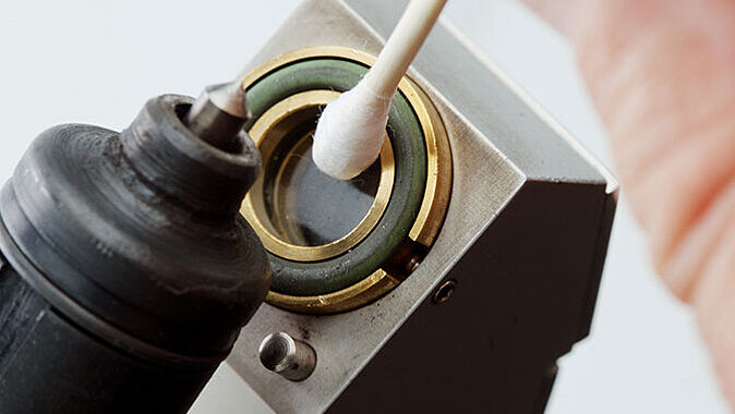 Close-up of the cleaning of the measurement window with a cotton swab