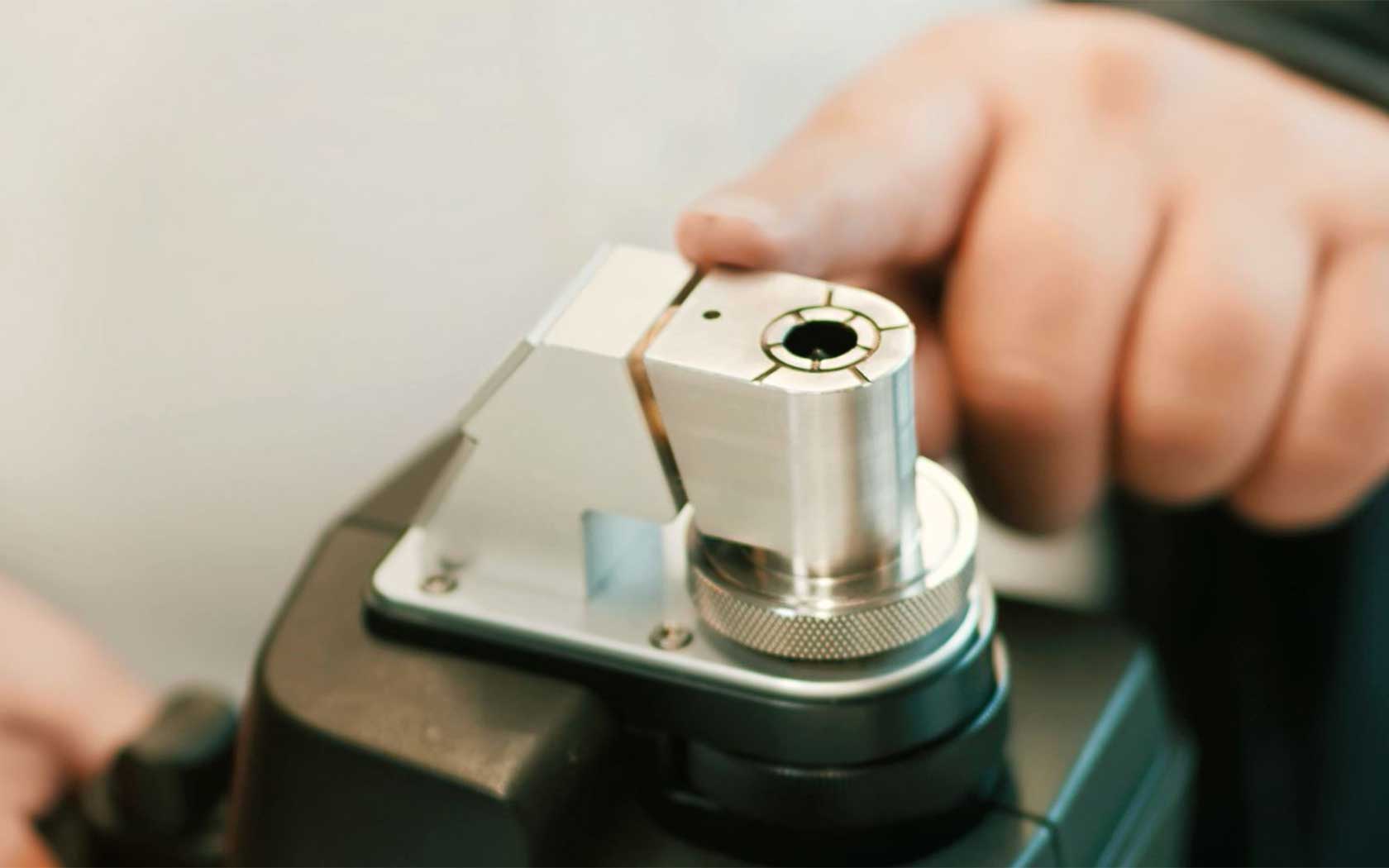 Hand on the top of a hand probe of a spark spectrometer