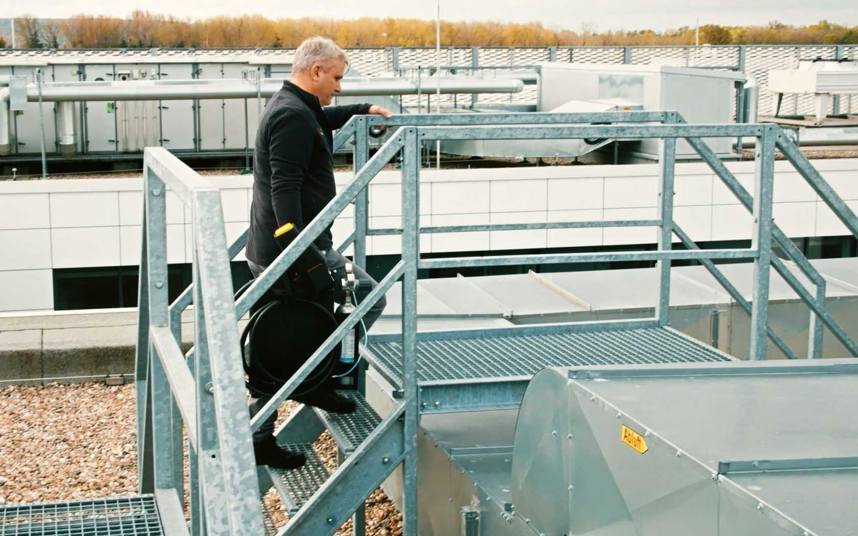 Man carries a mobile spectrometer upstairs