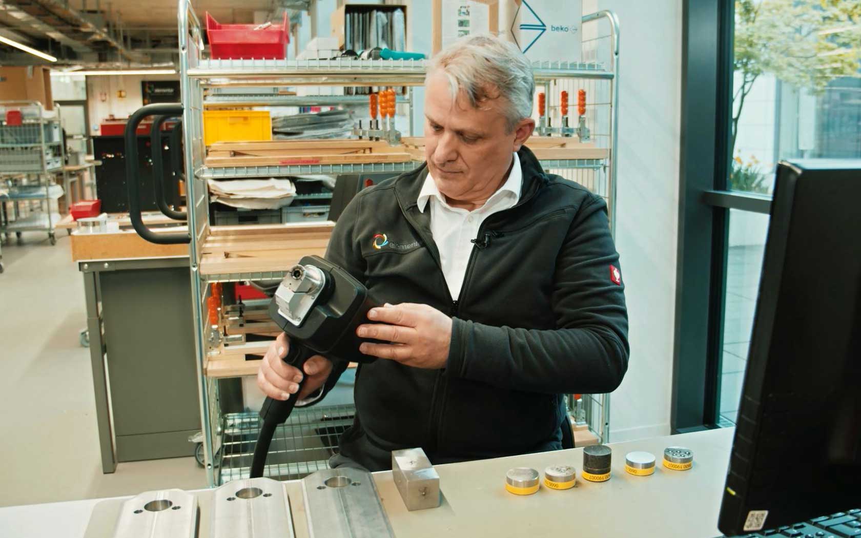 Mann, who is watching at the display of a spark spectrometer